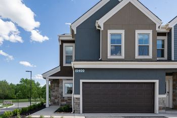 a home with a garage door in front of it at The Clearing at ONE28, Olathe